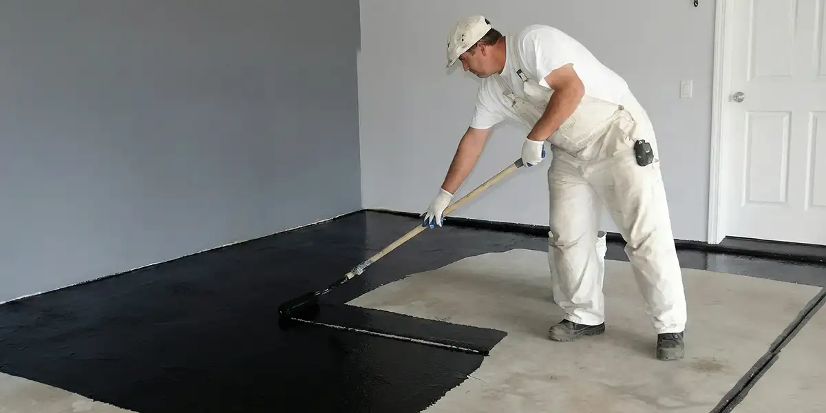 basement waterproofing professional applying waterproof coating to protect a basement floor in Ogden, UT